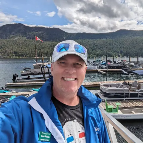 Sean Phillips smiling on a marina dock with boats behind him